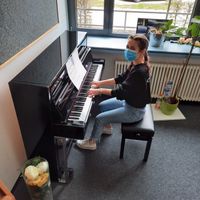 Klavier im Übungsraum des Ostendorfer-Gymnasiums mit Schülerin